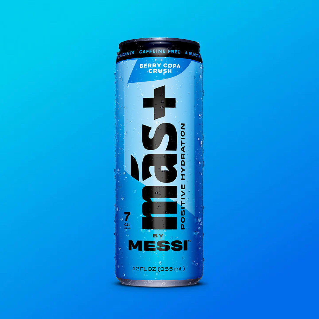 A blue can of "Más+ Positive Hydration by Messi" with water droplets on its surface, featuring the flavor "Berry Copa Crush" and a gradient blue background.