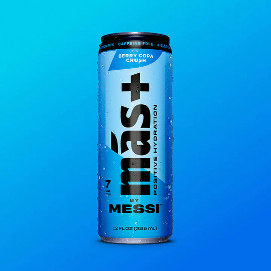 A blue can of "Más+ Positive Hydration by Messi" with water droplets on its surface, featuring the flavor "Berry Copa Crush" and a gradient blue background.