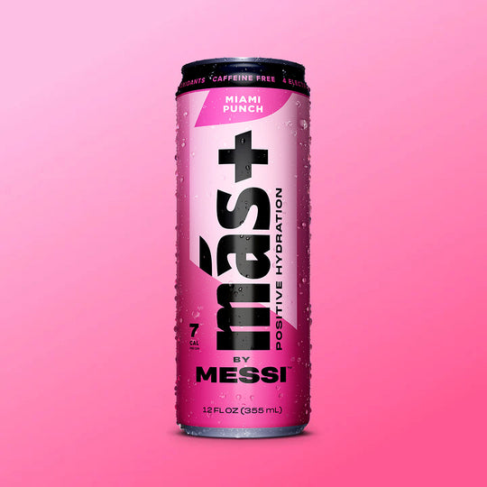 A pink can of "Más+ Positive Hydration by Messi" with water droplets on its surface, featuring the flavor "Berry Copa Crush" and a gradient pink background.