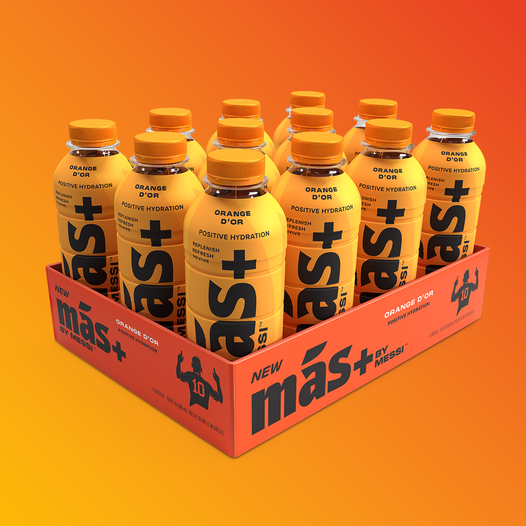 A set of orange-flavored Más+ by Messi hydration bottles arranged in a tray, with the packaging and label design visible, showcasing the product's bright orange color and branding.